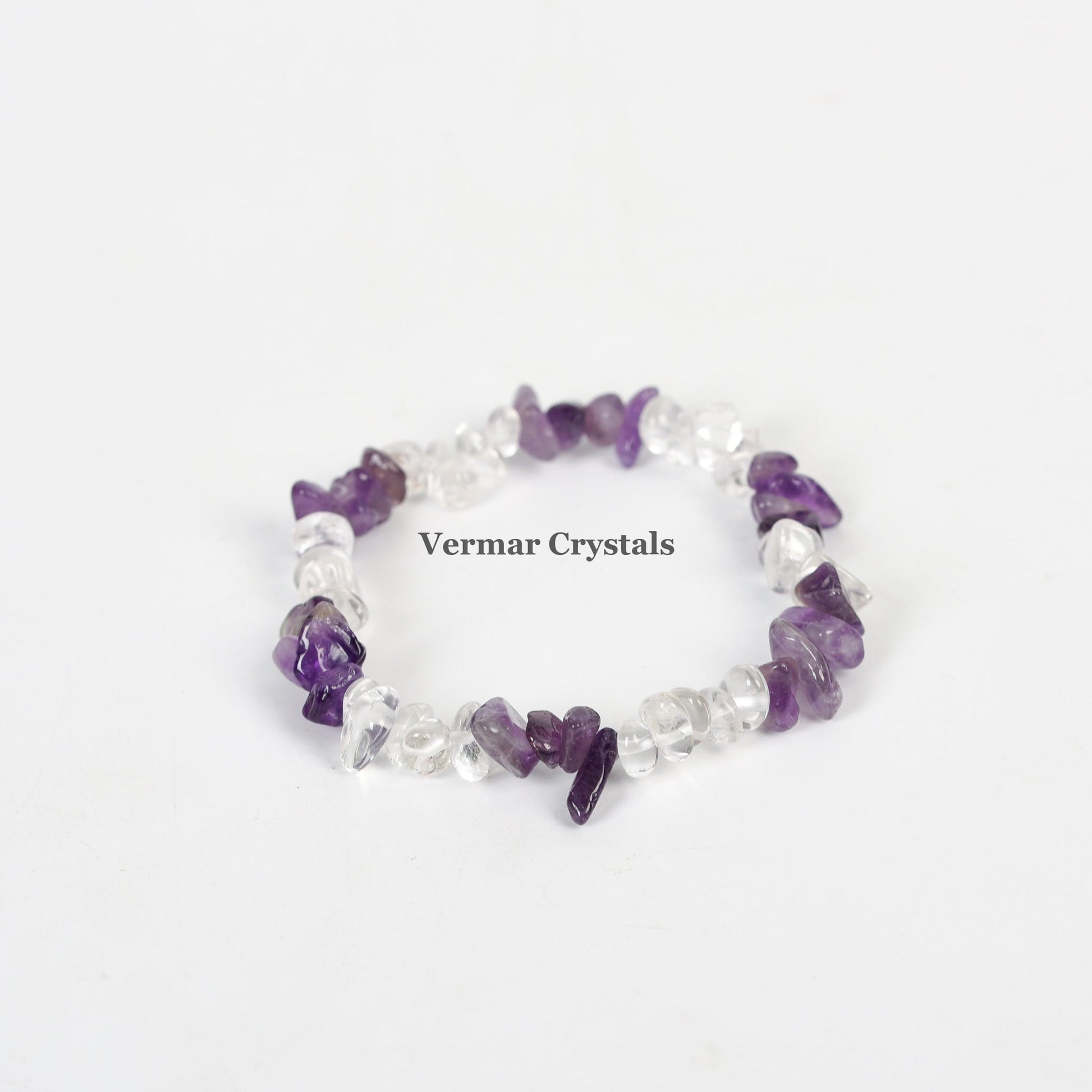 Stretchy bracelet made of irregular polished amethyst and clear quartz chip stones arranged in a circle on white background