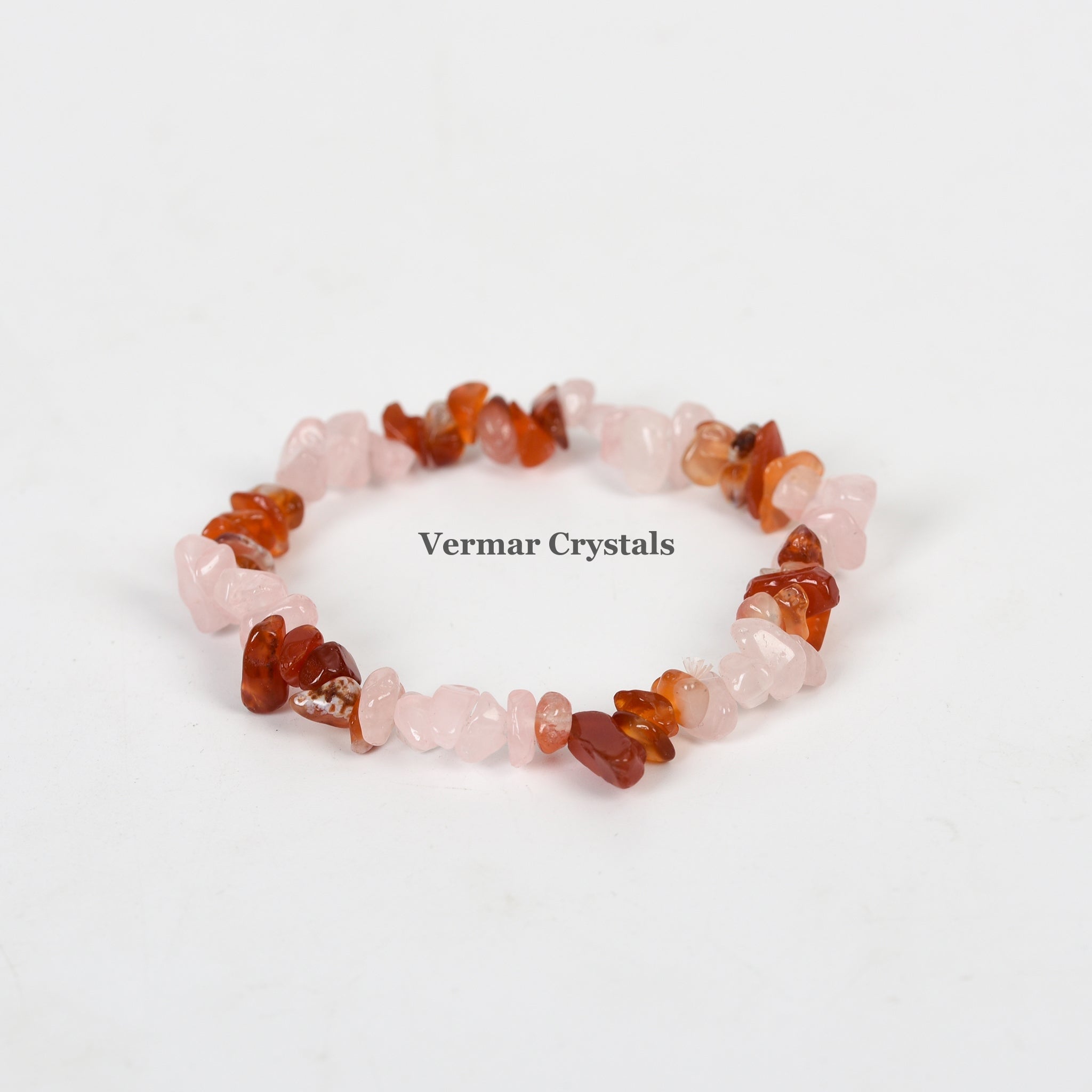 Handmade stretchy bracelet with polished rose quartz and red agate chip stones arranged in a circular shape on white background