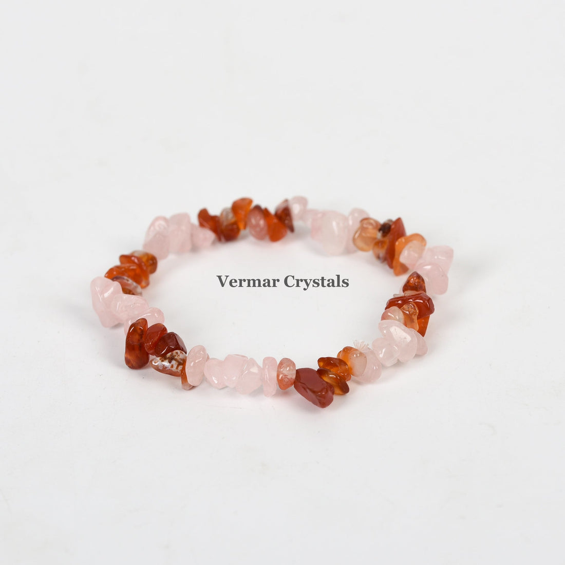 Handmade stretchy bracelet with polished rose quartz and red agate chip stones arranged in a circular shape on white background