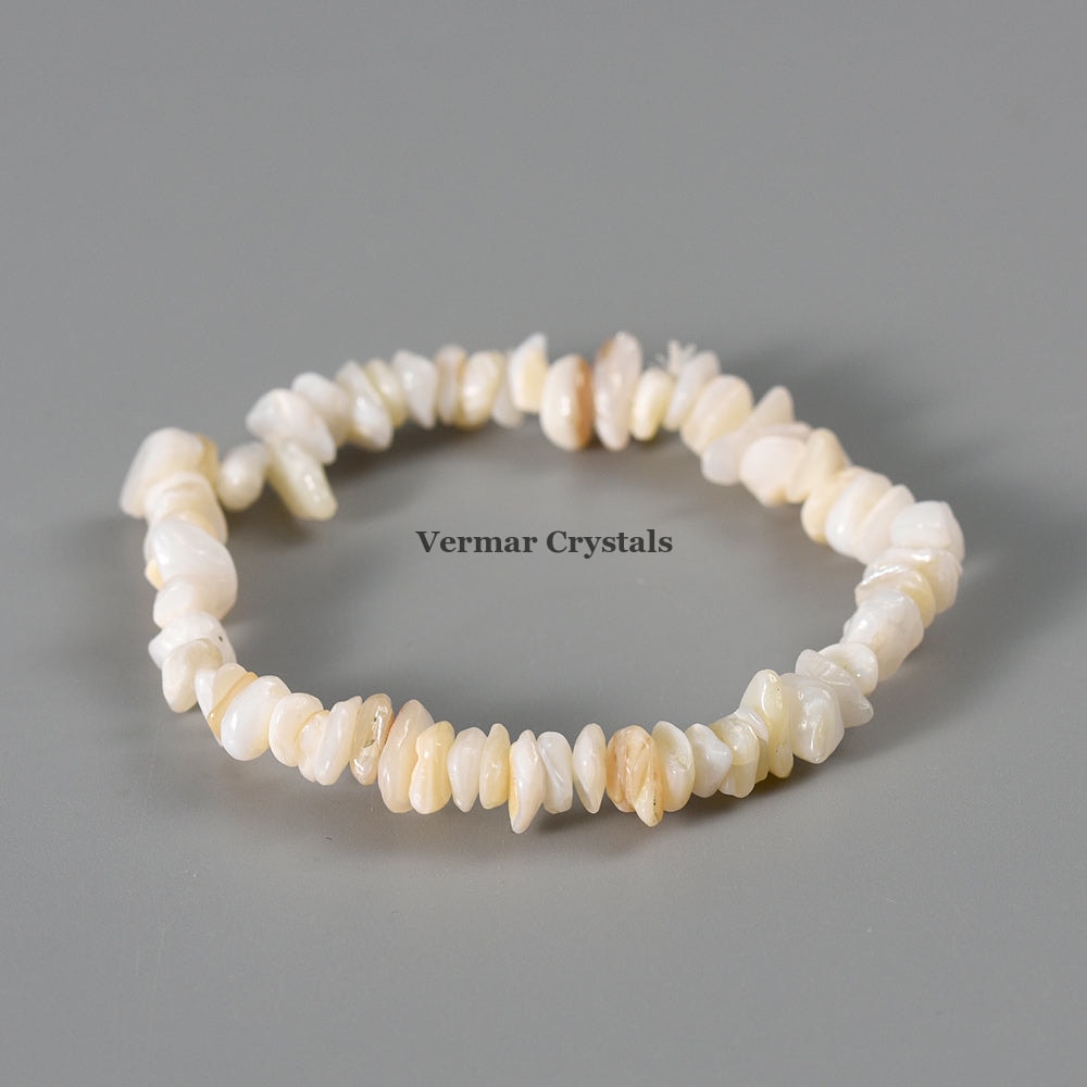 Handmade shell stone chip stretch bracelet with irregular polished cream and white stones on a gray background