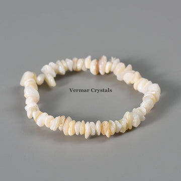 Handmade shell stone chip stretch bracelet with irregular polished cream and white stones on a gray background