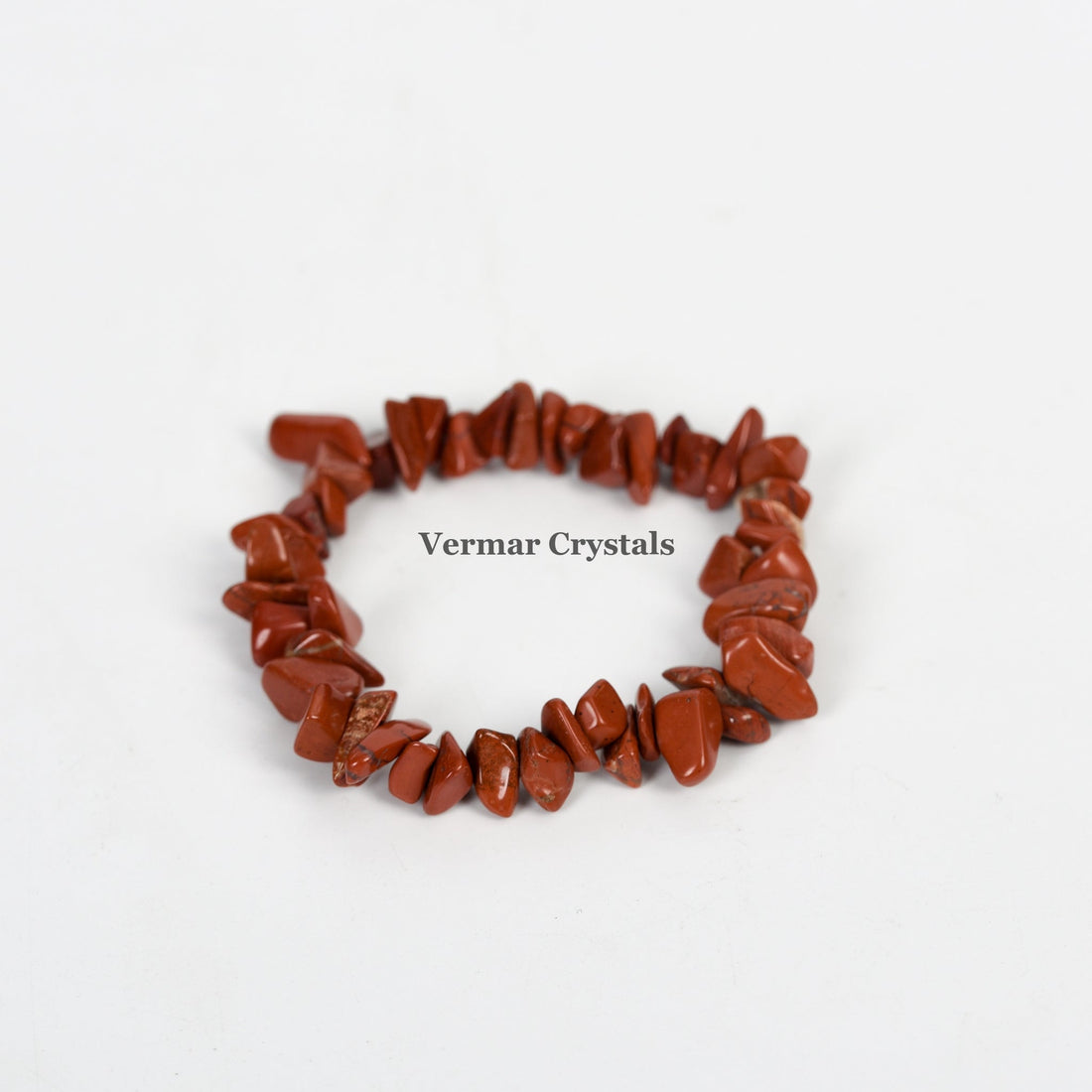 Stretchy bracelet made of irregular polished red jasper chip stones arranged in a circle on a white background