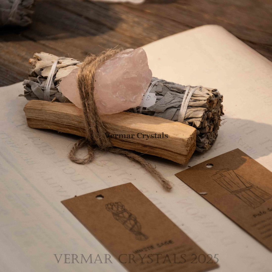 Bundle of Mexican white sage, palo santo stick, and raw rose quartz tied with twine for cleansing and healing rituals