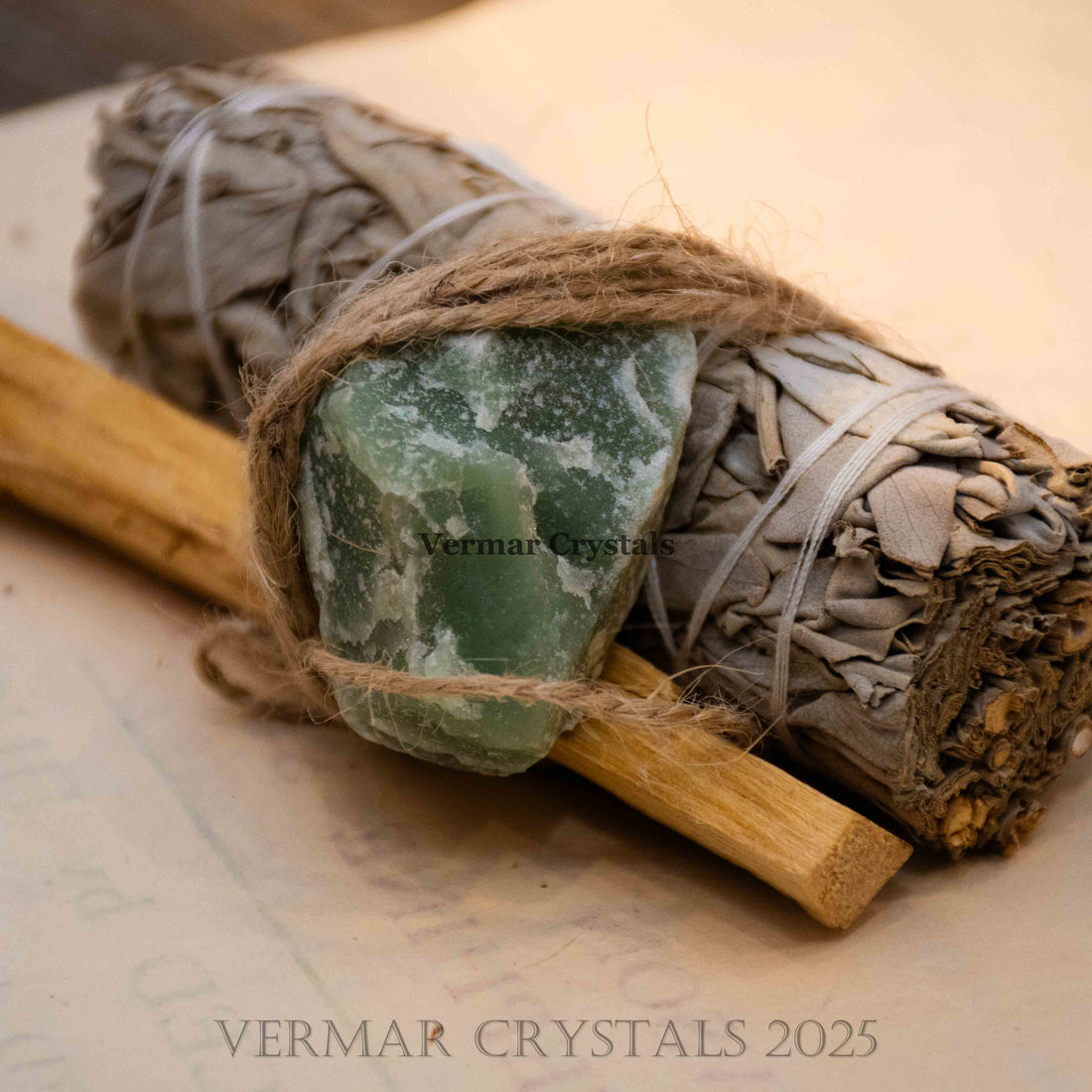 Energy cleansing set featuring Mexican white sage bundle, Palo Santo stick, and green aventurine stone tied with twine on white background