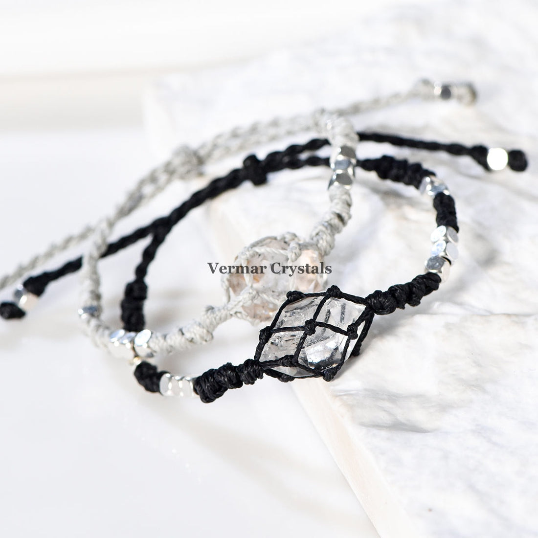 Handcrafted Herkimer Diamond crystal bracelets with durable braided cord and silver bead accents on white background