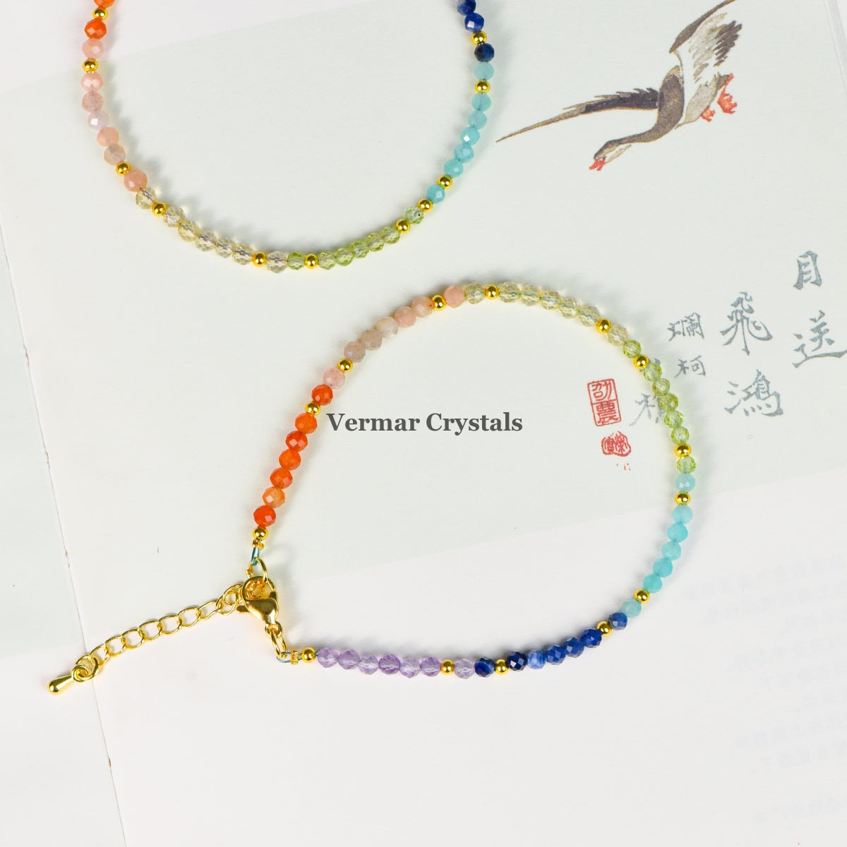 Seven faceted natural gemstone beads representing chakras with gold accents on an adjustable bracelet chain
