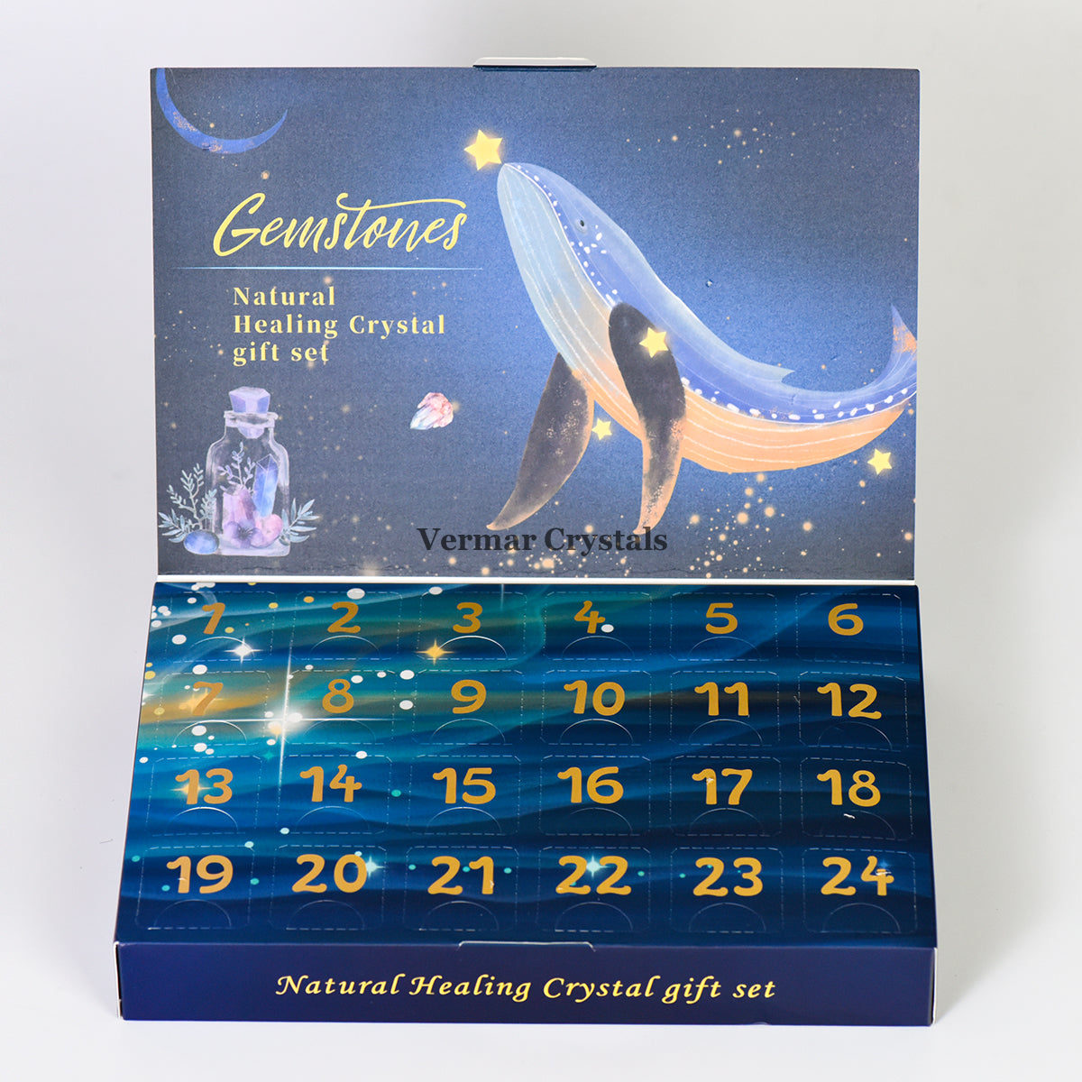 Mystery box with natural raw healing crystals arranged in numbered compartments against a celestial whale design background