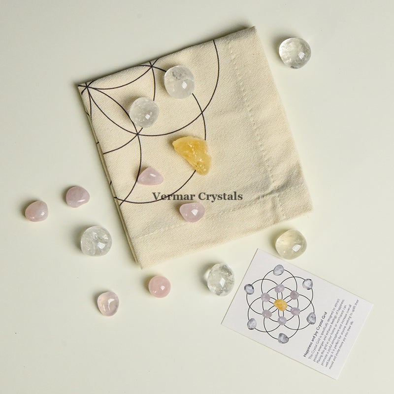 Happiness and Joy crystal grid set with clear quartz and rose quartz stones arranged on fabric cloth for positive energy