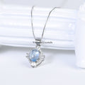 Elegant aquamarine blue oval pendant with halo of sparkling stones on delicate silver chain against white background