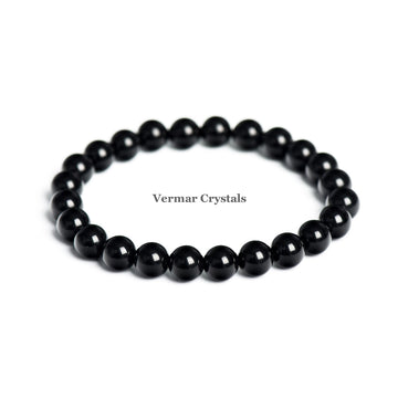 Stretchy bracelet made of polished 8mm black obsidian round beads arranged in a circle on a white background