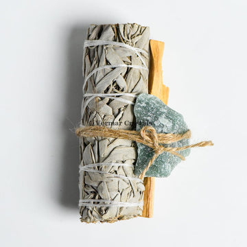 Energy cleansing set featuring Mexican white sage bundle, Palo Santo stick, and green aventurine stone tied with twine on white background