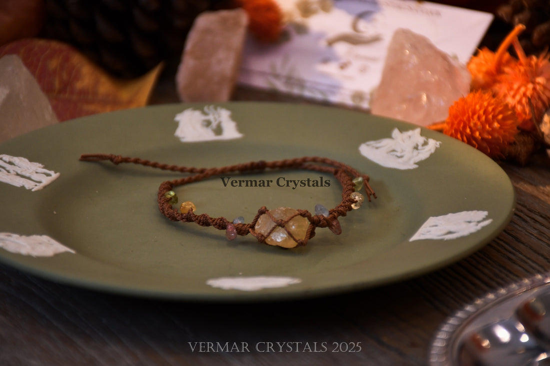 Handmade citrine gemstone cord bracelet with green and pink crystal accents on a textured light surface with paper background