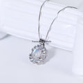 Elegant silver pendant featuring an oval blue moonstone surrounded by sparkling clear gemstones on a delicate chain