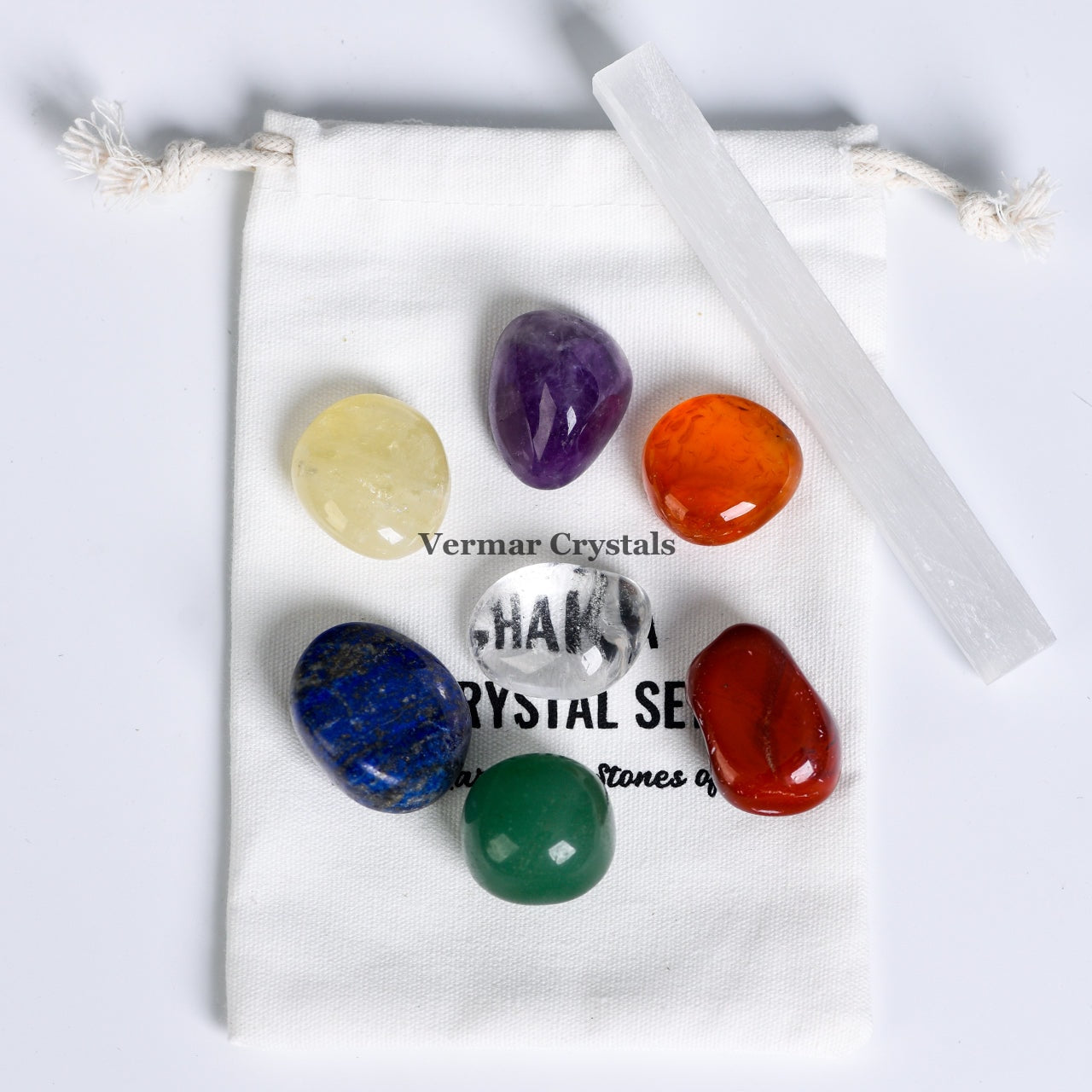 Seven Chakra Healing Crystal Set with polished stones and selenite wand displayed on a white drawstring pouch