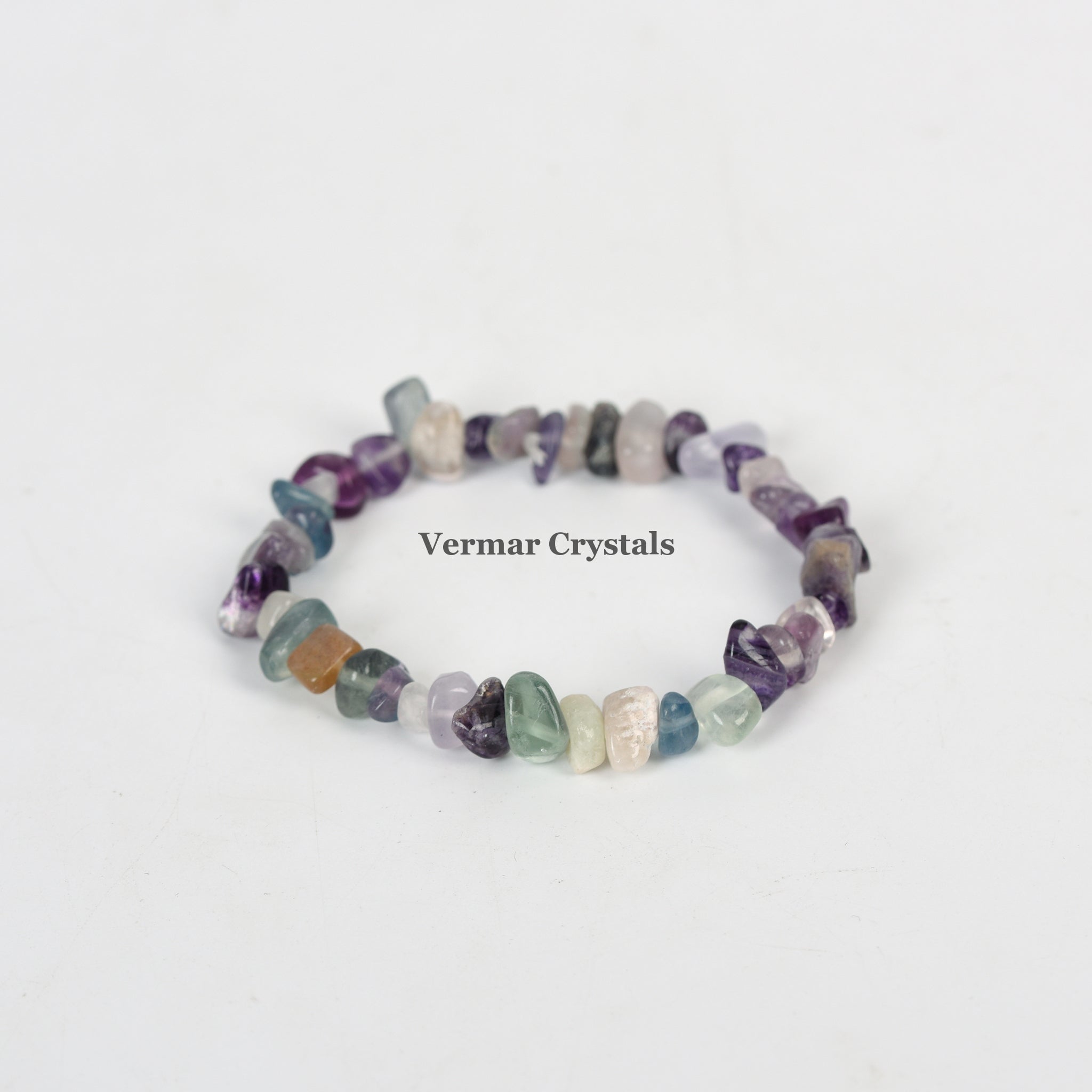 Stretchy handmade bracelet made of irregular multi-colored fluorite chip stones arranged in a circle on white background