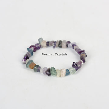 Stretchy handmade bracelet made of irregular multi-colored fluorite chip stones arranged in a circle on white background