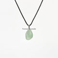 Natural raw green fluorite pendant necklace with soft translucent green stone on black cord background white