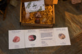 Boxed Love & Happiness Crystal Set with rose quartz, rhodonite, strawberry quartz, flower agate stones and informational cards on wood table