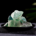 Natural green fluorite crystal stones with translucent and rough textures displayed on a black dish