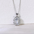Silver pendant necklace featuring an oval blue moonstone surrounded by sparkling crystal accents on white background