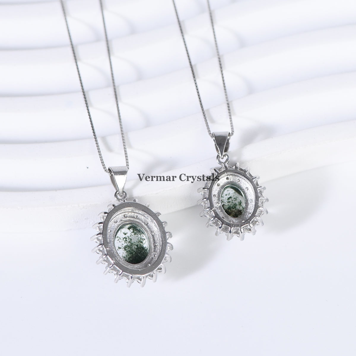 Two elegant silver necklaces with green phantom quartz center stones and halo settings on white background