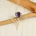 Handcrafted amethyst rose pendant wrapped in silver wire on a delicate silver chain against a light background