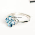 Silver ring featuring four heart-shaped blue gemstones arranged as a lucky four-petal flower on white background