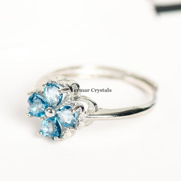 Silver ring featuring four heart-shaped blue gemstones arranged as a lucky four-petal flower on white background