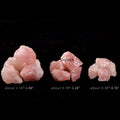Natural rose quartz crystal stones in three size ranges against a black background for healing and meditation use