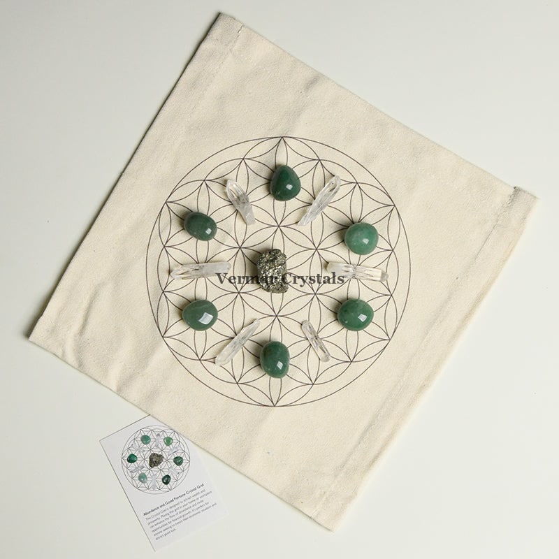 Abundance and good luck crystal grid set with green stones and clear quartz on fabric cloth for prosperity and success.