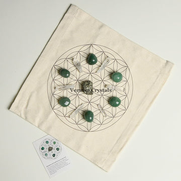 Abundance and good luck crystal grid set with green stones and clear quartz on fabric cloth for prosperity and success.