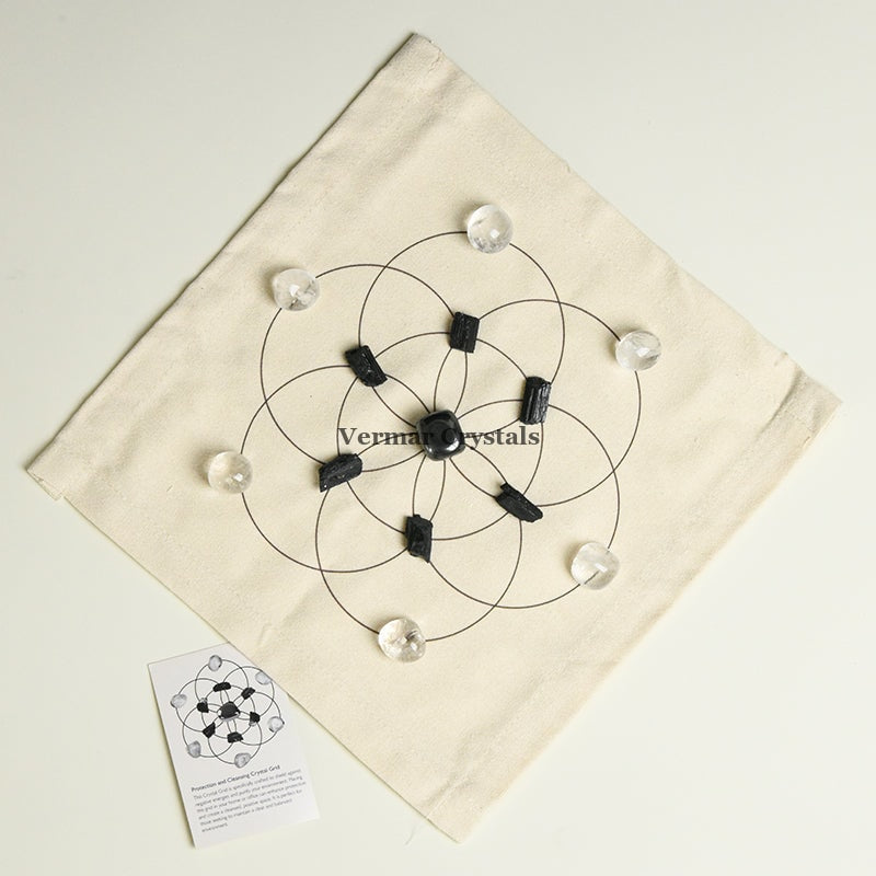 Protection and cleansing crystal grid set with black and clear stones arranged on fabric cloth for energy purification and shielding