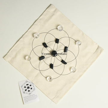 Protection and cleansing crystal grid set with black and clear stones arranged on fabric cloth for energy purification and shielding