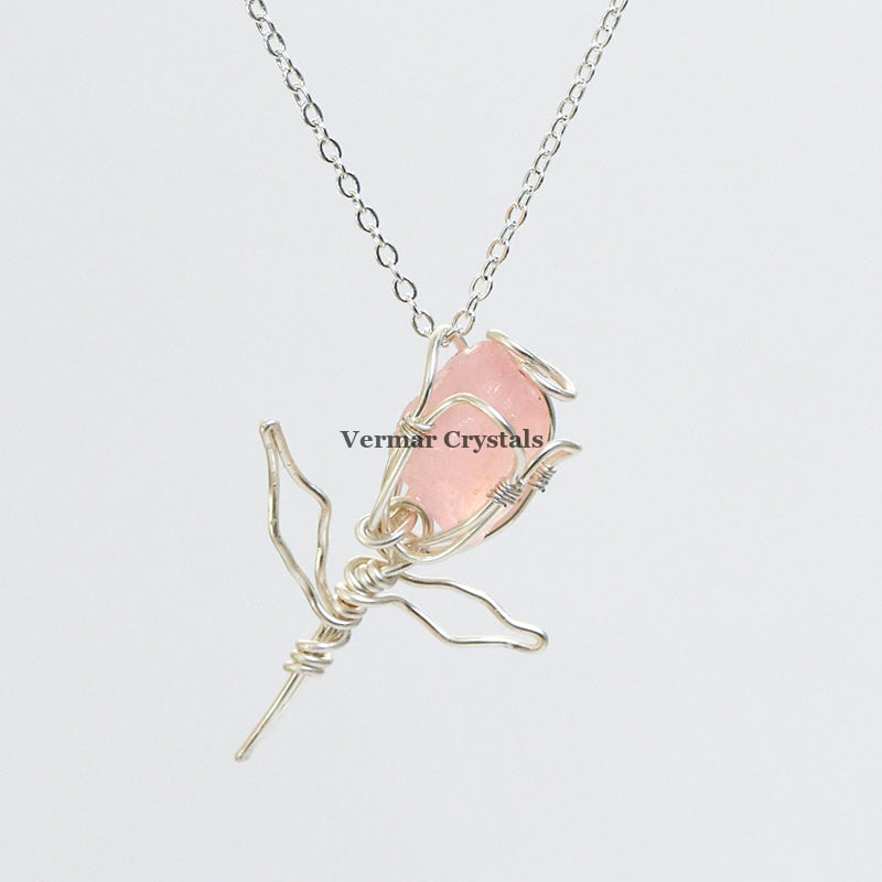 Handcrafted rose quartz rose pendant wrapped in silver wire on a delicate silver chain necklace against a white background