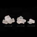 Three naturally formed clear quartz stones in varying sizes displayed against a black background with size measurements.