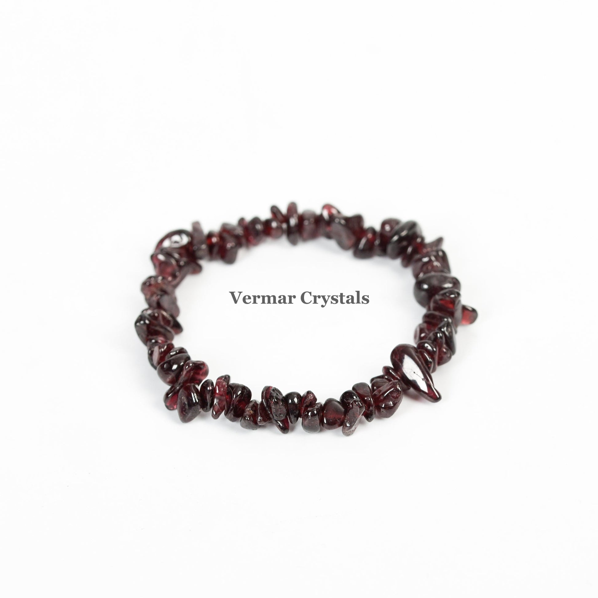 Handmade garnet chip bracelet with polished deep red irregular stones arranged in a circular shape on white background