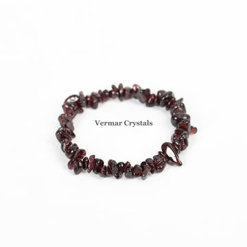 Handmade garnet chip bracelet with polished deep red irregular stones arranged in a circular shape on white background