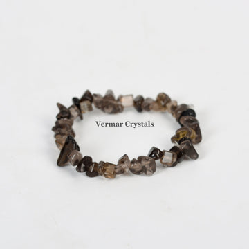 Handmade stretchy bracelet made of polished smoky quartz chip beads arranged in a circular shape on white background