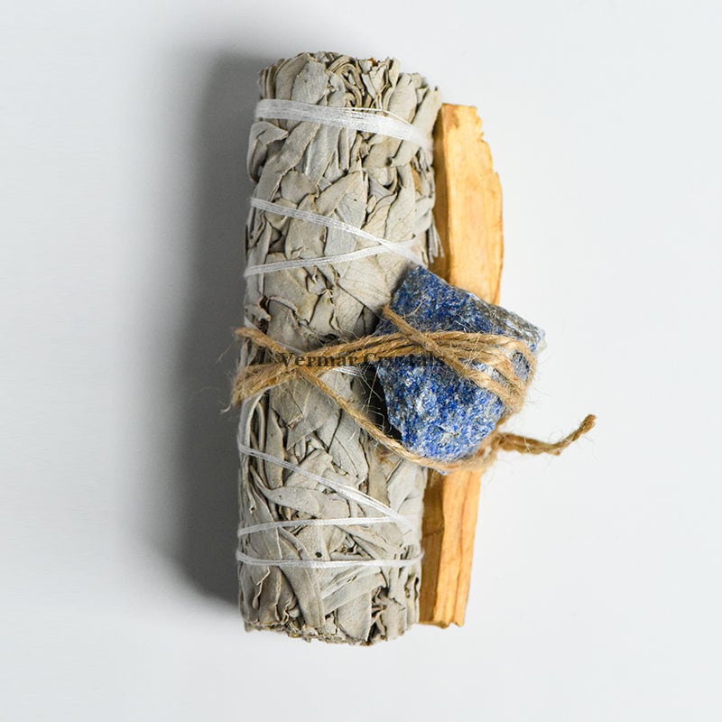Bundle of white sage, Palo Santo stick, and blue Lapis Lazuli stone tied with natural twine for healing rituals.