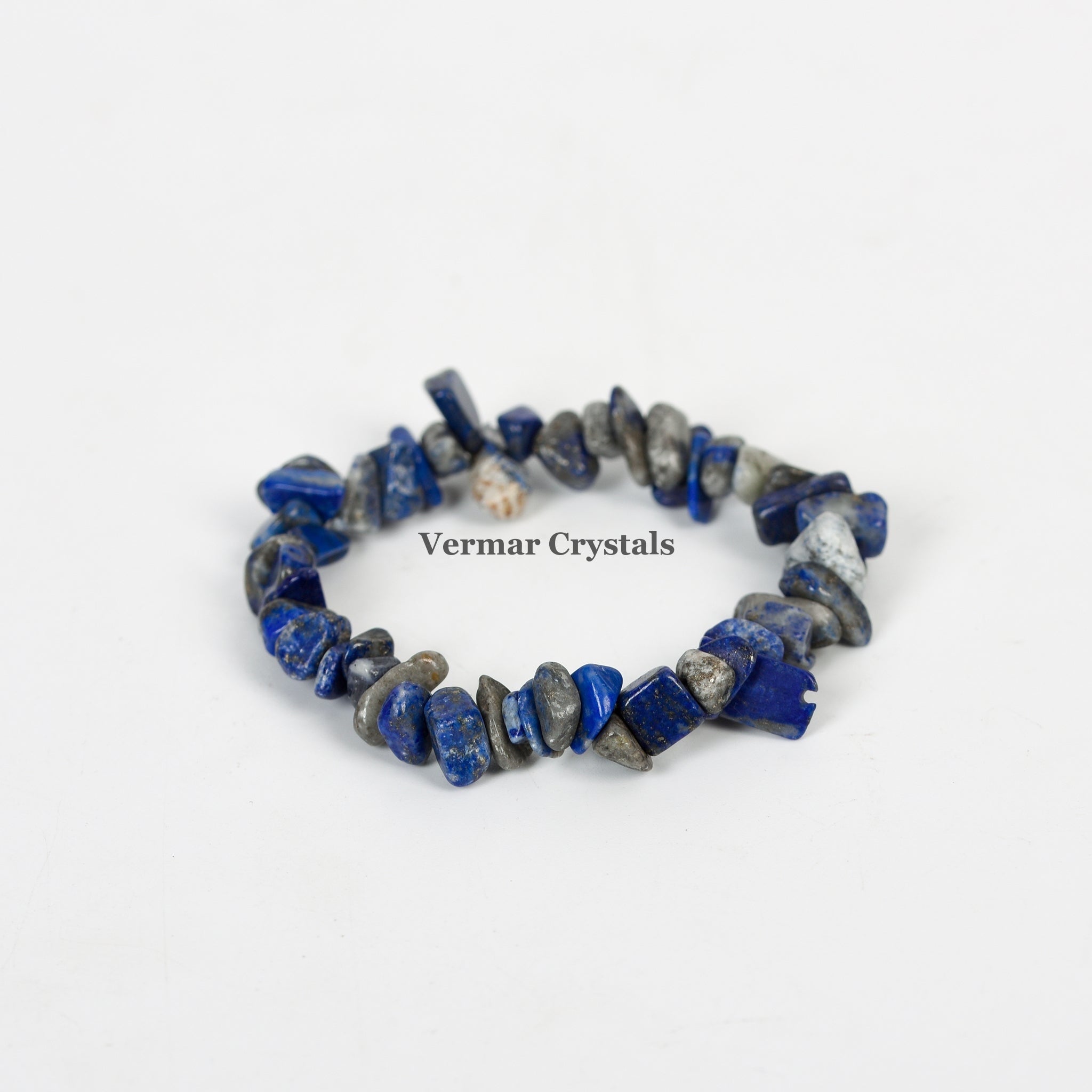 Handmade stretchy bracelet made of irregular polished blue and gray lapis lazuli chip stones on a white background
