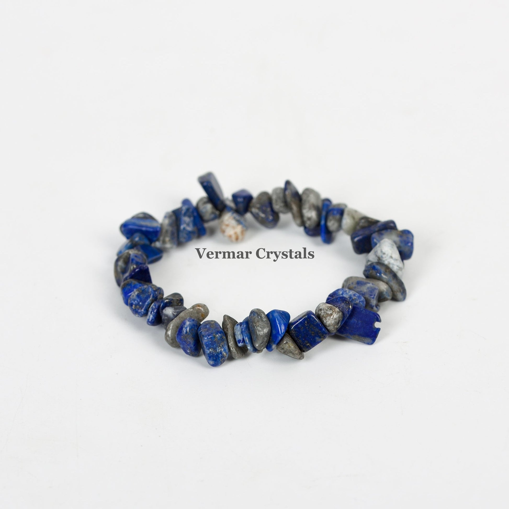 Handmade stretchy bracelet made of irregular polished blue and gray lapis lazuli chip stones on a white background