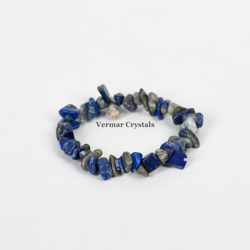 Handmade stretchy bracelet made of irregular polished blue and gray lapis lazuli chip stones on a white background