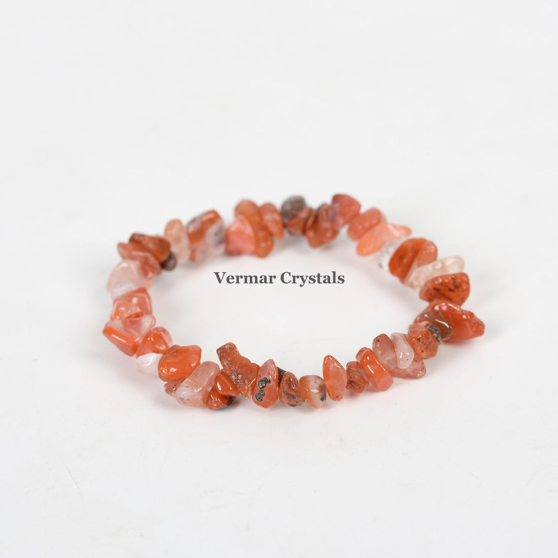 Handmade stretchy bracelet made of irregular polished red agate chip stones arranged in a circle on white background