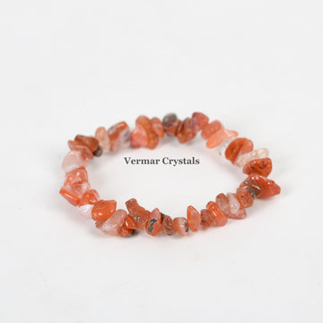 Handmade stretchy bracelet made of irregular polished red agate chip stones arranged in a circle on white background