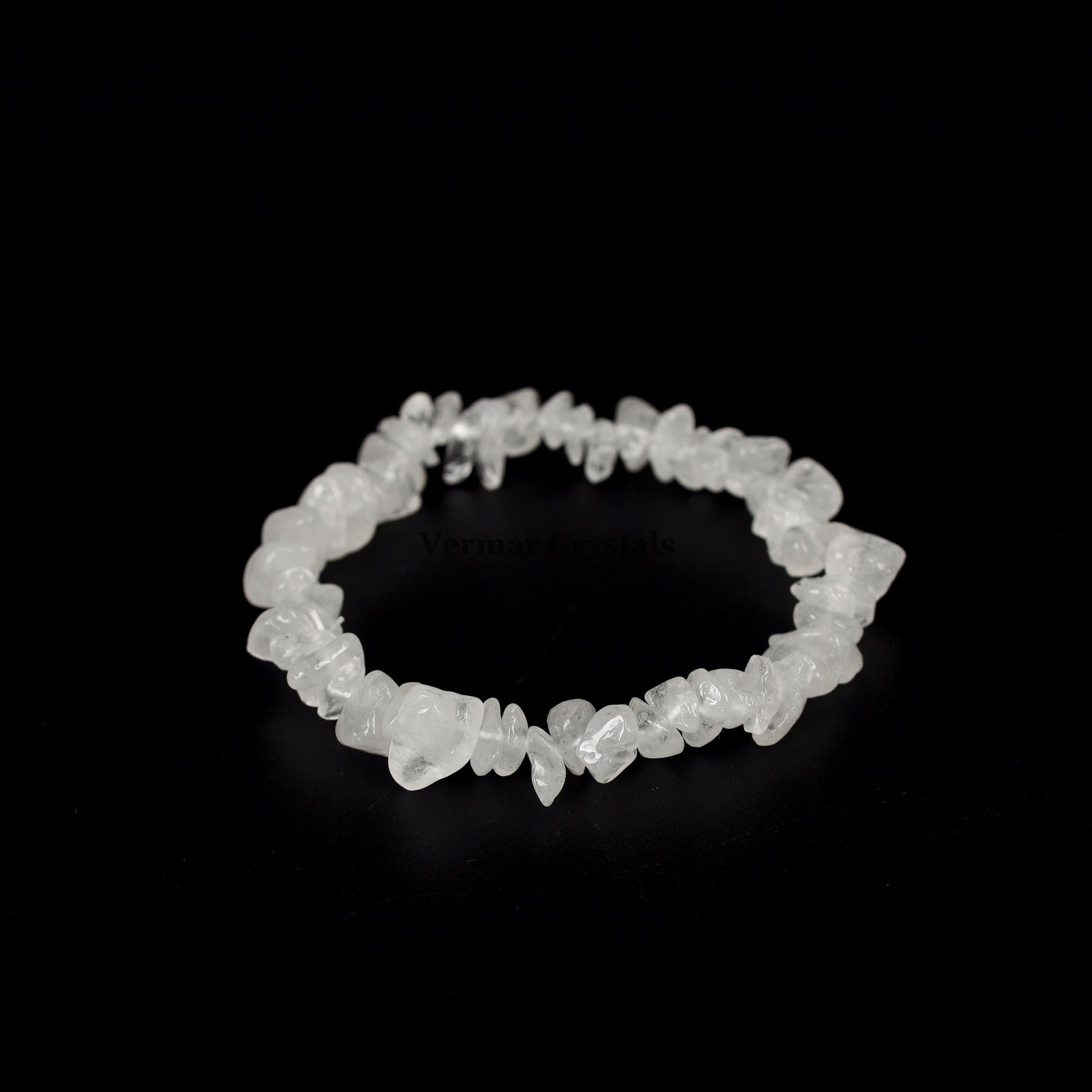 Handmade clear quartz chip bracelet with irregular polished translucent stones arranged in a circular shape on black background