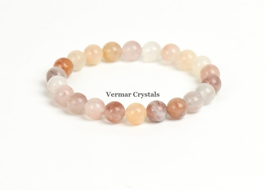 Stretchy bracelet made of polished round multicolored stone beads arranged in a circle on a white background