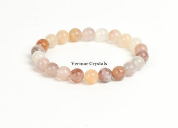 Stretchy bracelet made of polished round multicolored stone beads arranged in a circle on a white background