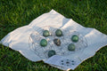 Abundance and good luck crystal grid set featuring green stones on a fabric cloth with geometric design outdoors on grass