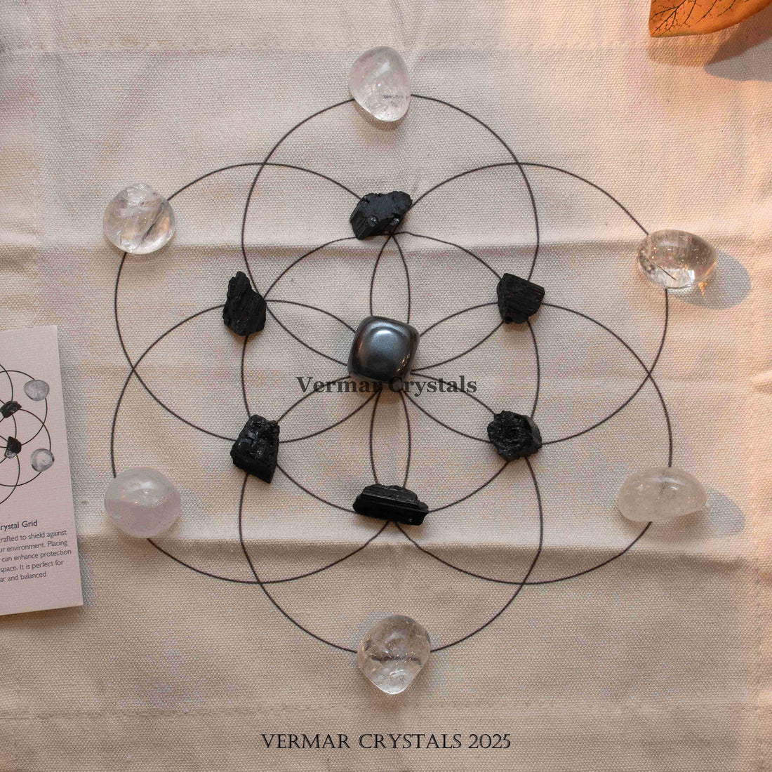 Protection and cleansing crystal grid set with black and clear stones arranged on fabric cloth for energy purification and shielding