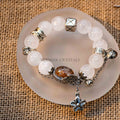 White and Garden Phantom Quartz bracelet with silver accents and a decorative flower charm on frosted round plate
